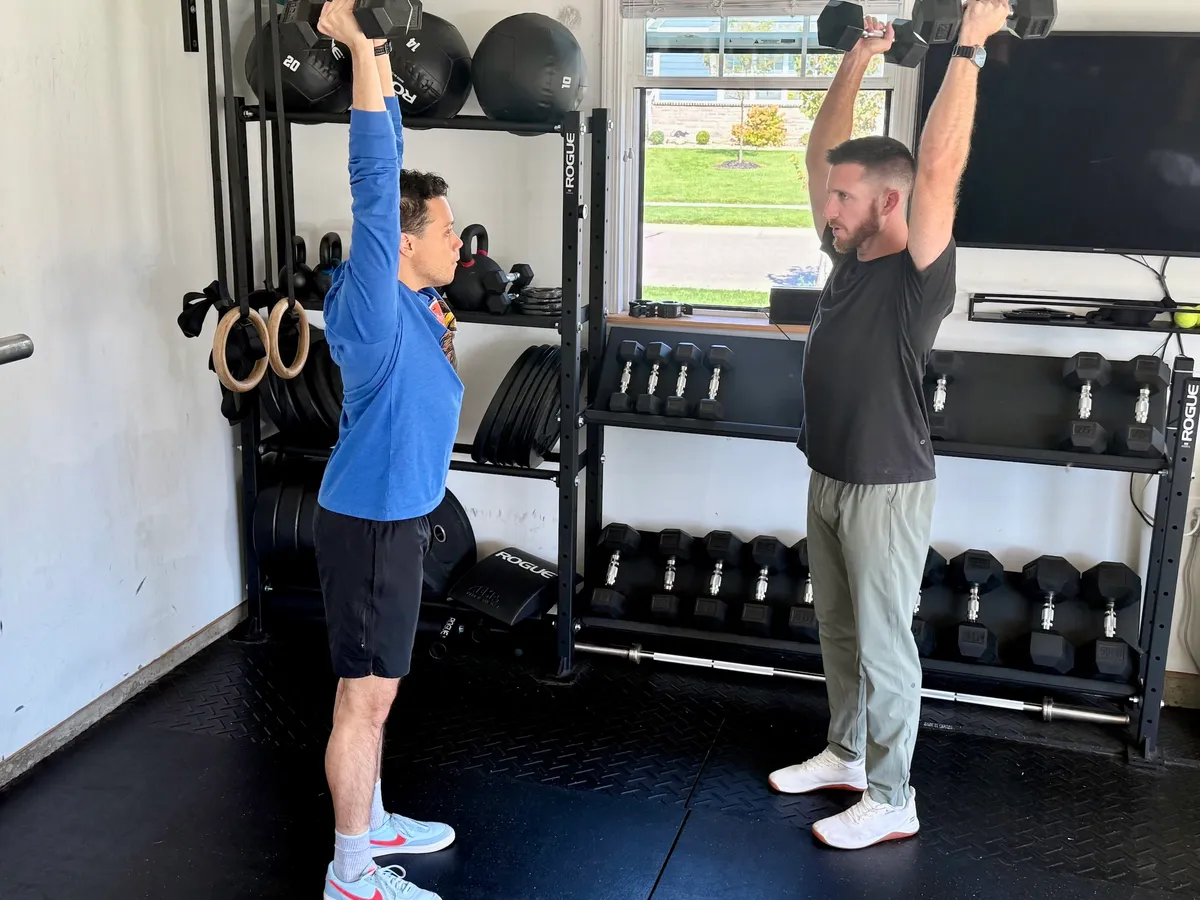 Ryan Summitt coaching a client through an overhead dumbbell press