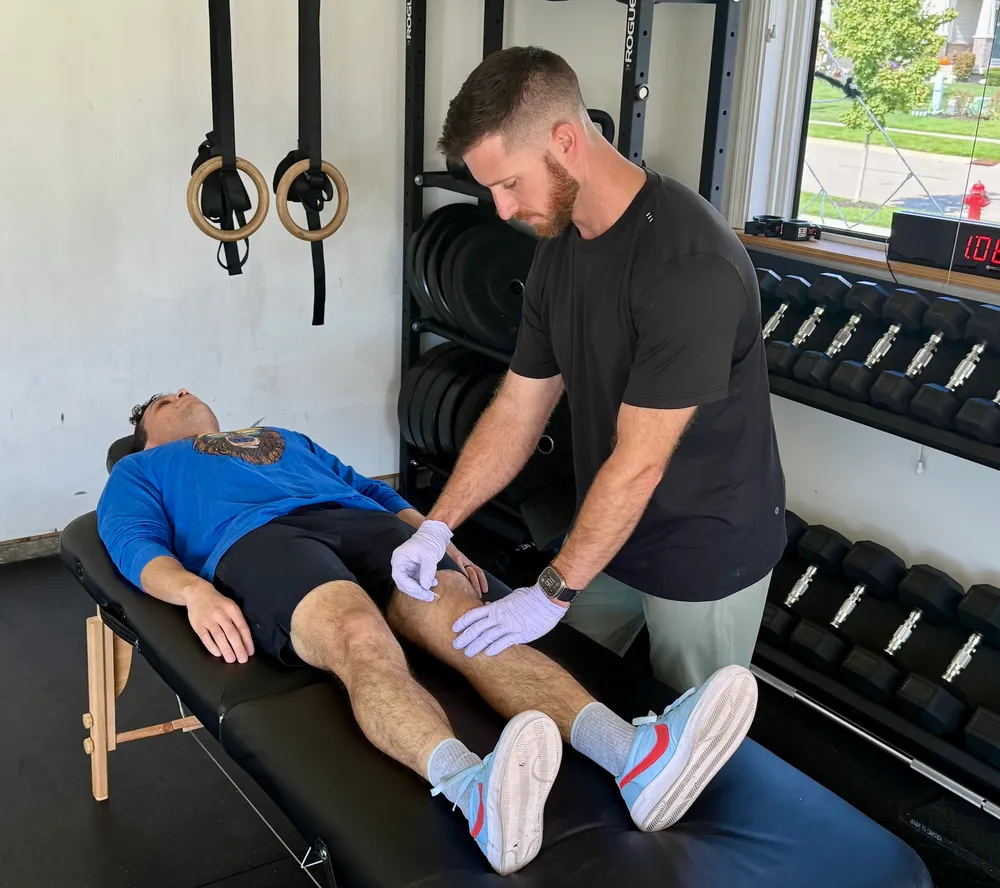 Ryan Summitt performing dry needling on a patient’s thigh